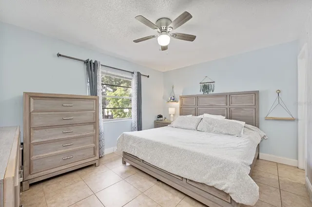 a bedroom with a bed and a ceiling fan