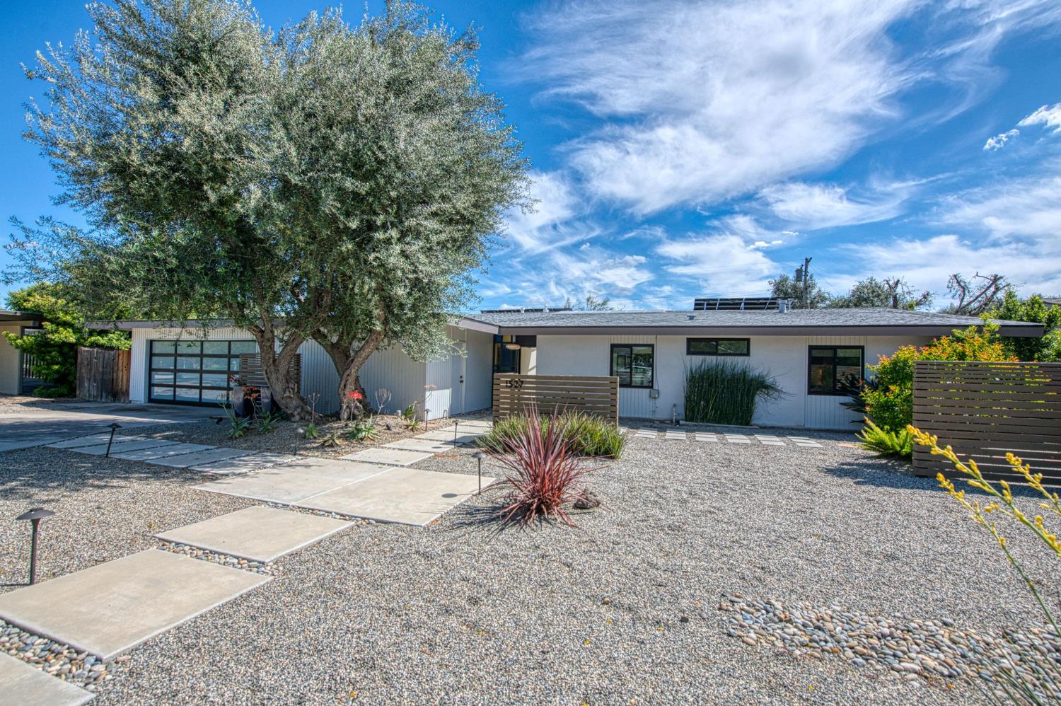 a view of a house with backyard and a tree