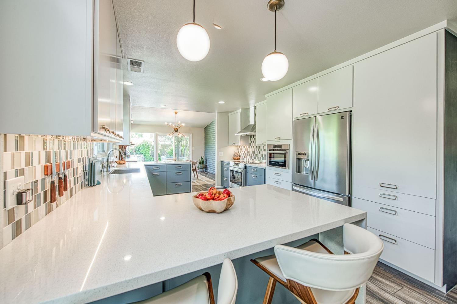 1527 West San Ramon Avenue Fresno, CA 93711 - Photo 13 of 55 a kitchen with a dining table chairs and white cabinets