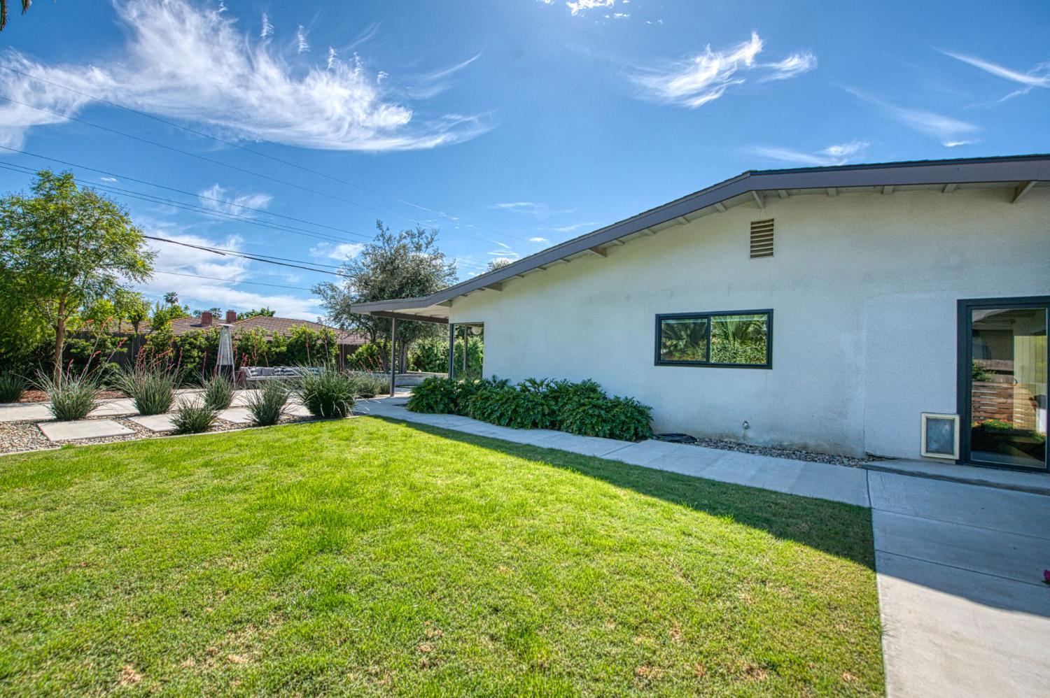 1527 West San Ramon Avenue Fresno, CA 93711 - Photo 45 of 55 a view of a house with a backyard porch and sitting area