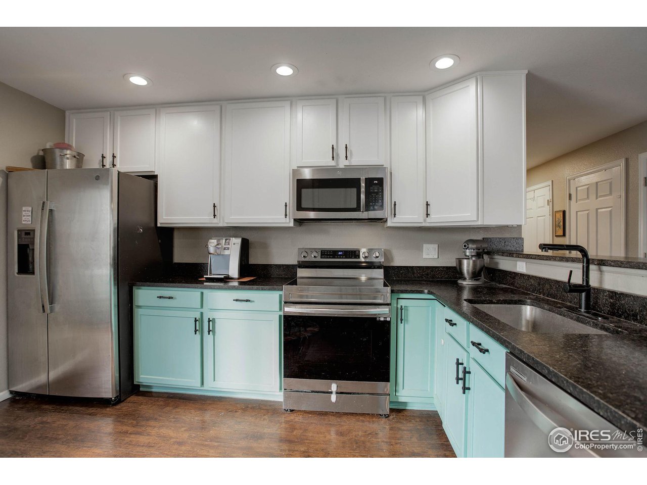 1205 Trail Ridge Road Longmont, CO 80504 - Photo 11 of 23 a kitchen with stainless steel appliances granite countertop a stove a refrigerator a sink and a microwave