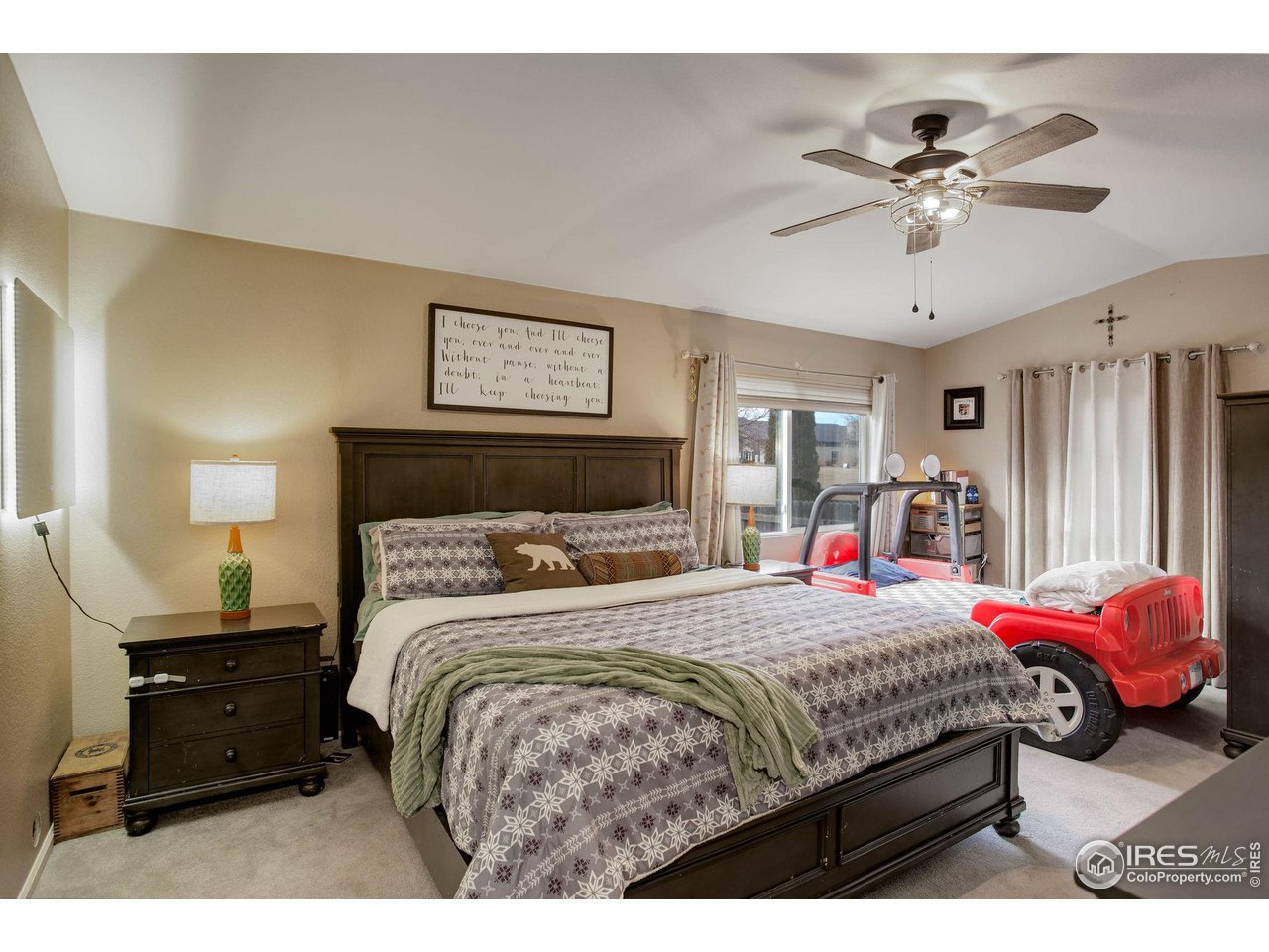 1205 Trail Ridge Road Longmont, CO 80504 - Photo 13 of 23 a bedroom with a bed and a chandelier