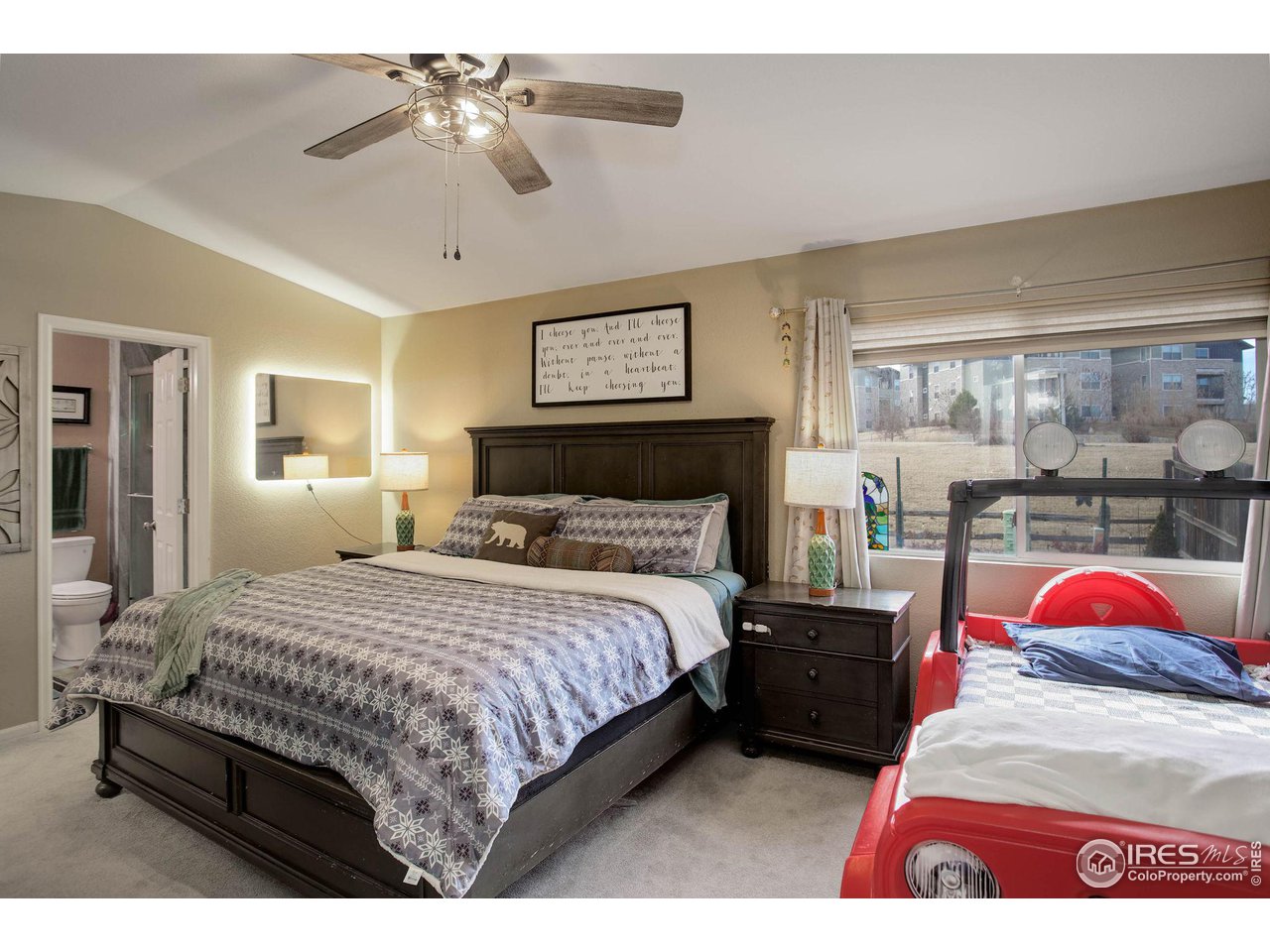 1205 Trail Ridge Road Longmont, CO 80504 - Photo 14 of 23 a bedroom with a bed and a chandelier