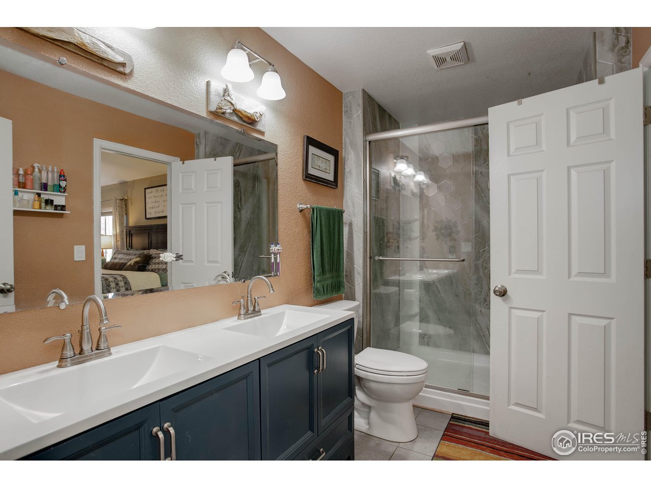 1205 Trail Ridge Road Longmont, CO 80504 - Photo 17 of 23 a bathroom with a double vanity sink toilet and shower