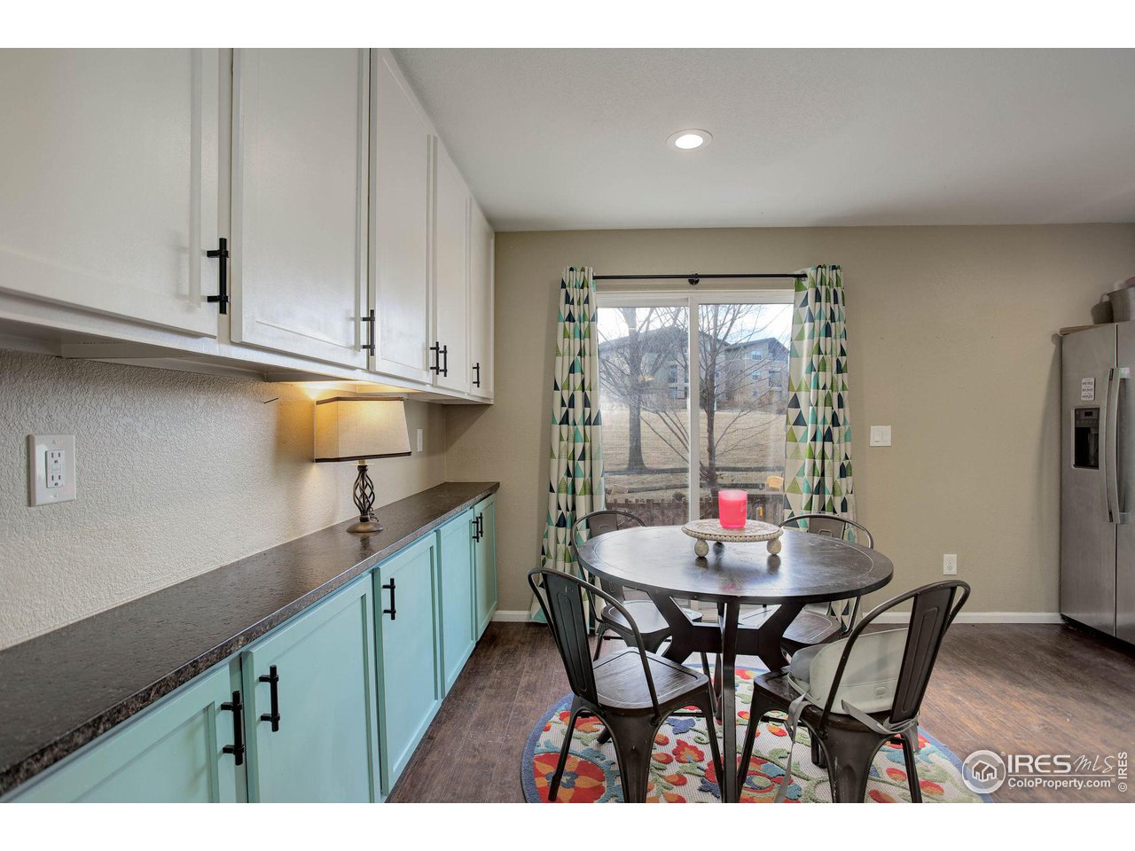 1205 Trail Ridge Road Longmont, CO 80504 - Photo 7 of 23 a kitchen with a dining table chairs and cabinets