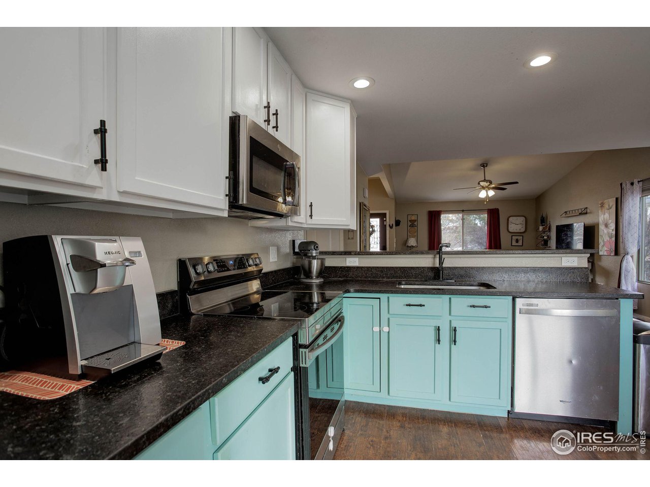 1205 Trail Ridge Road Longmont, CO 80504 - Photo 10 of 23 a kitchen with stainless steel appliances granite countertop a sink stove and microwave