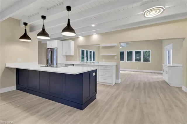 a kitchen with kitchen island granite countertop a sink cabinets and wooden floor