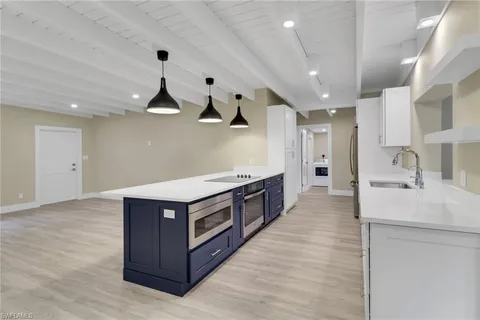 a kitchen with stainless steel appliances a stove a sink and a refrigerator