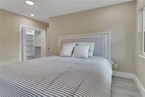 a bedroom with a bed and a painting on the wall