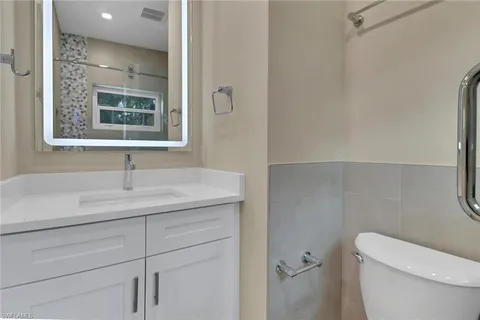 a bathroom with a toilet a sink and mirror
