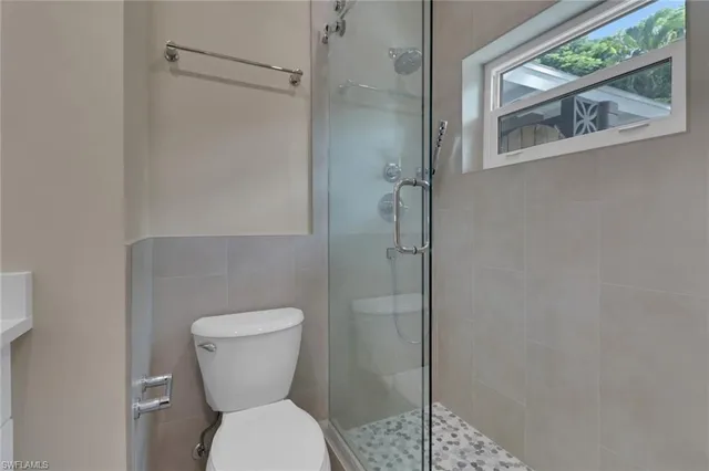 a white toilet sitting next to a shower