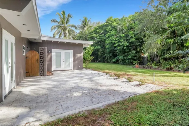 a view of a house with a yard and potted plants