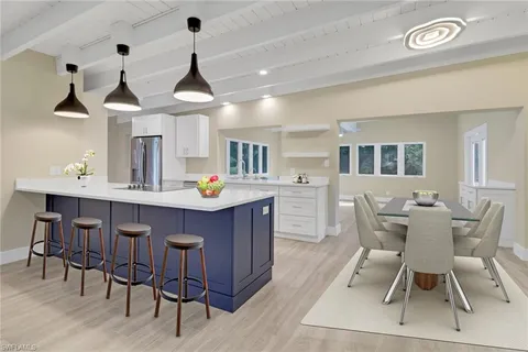 a dining room with wooden floor and chandelier