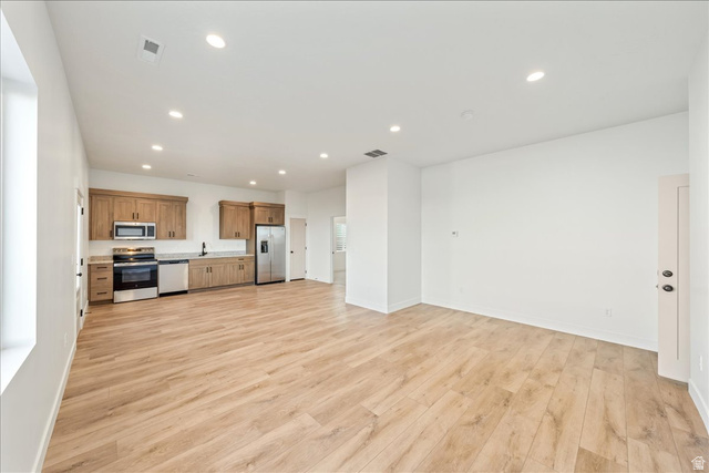 1491 East Centaurus Way, Unit 86 Washington, UT 84780 - Photo 26 of 26 Kitchen with recessed lighting, appliances with stainless steel finishes, brown cabinets, open floor plan, and light wood-style flooring