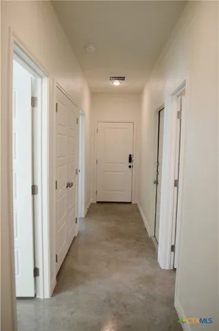 a view of a hallway with wooden shelves