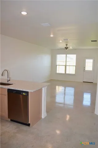 a view of an empty room with wooden floor and windows