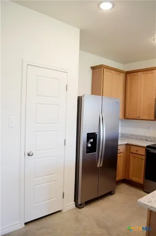 a kitchen with stainless steel appliances granite countertop a refrigerator and a stove