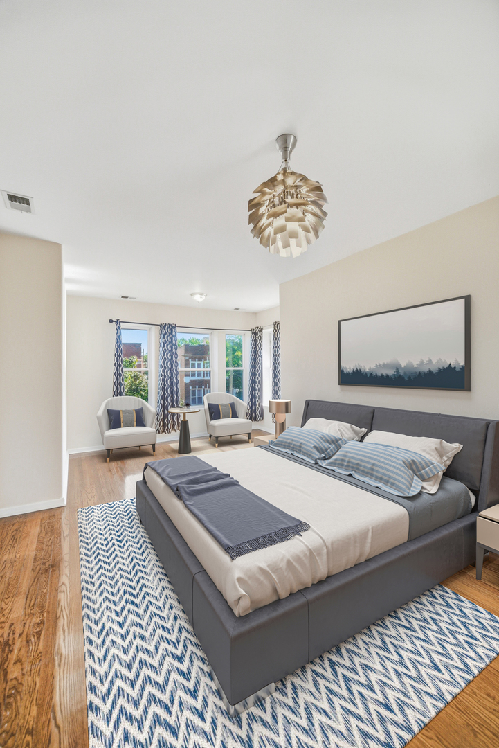 6712 South Ridgeland Avenue, Unit 3A Chicago, IL 60649 - Photo 2 of 14 a bedroom with a large bed and a chandelier