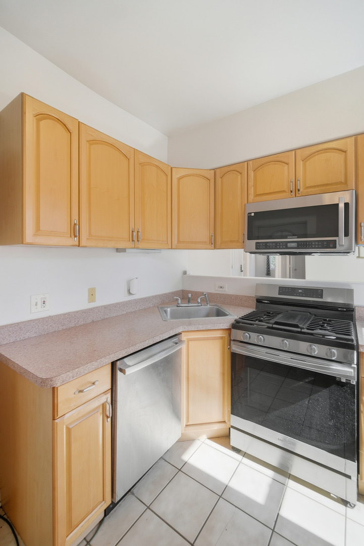 6712 South Ridgeland Avenue, Unit 3A Chicago, IL 60649 - Photo 10 of 14 a kitchen with granite countertop a stove cabinets and a sink