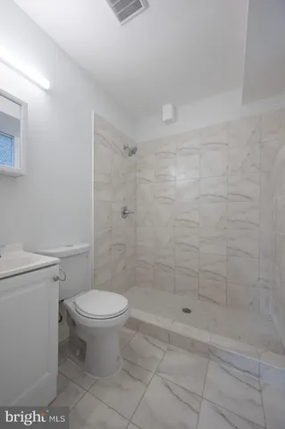 a bathroom with a toilet and a shower
