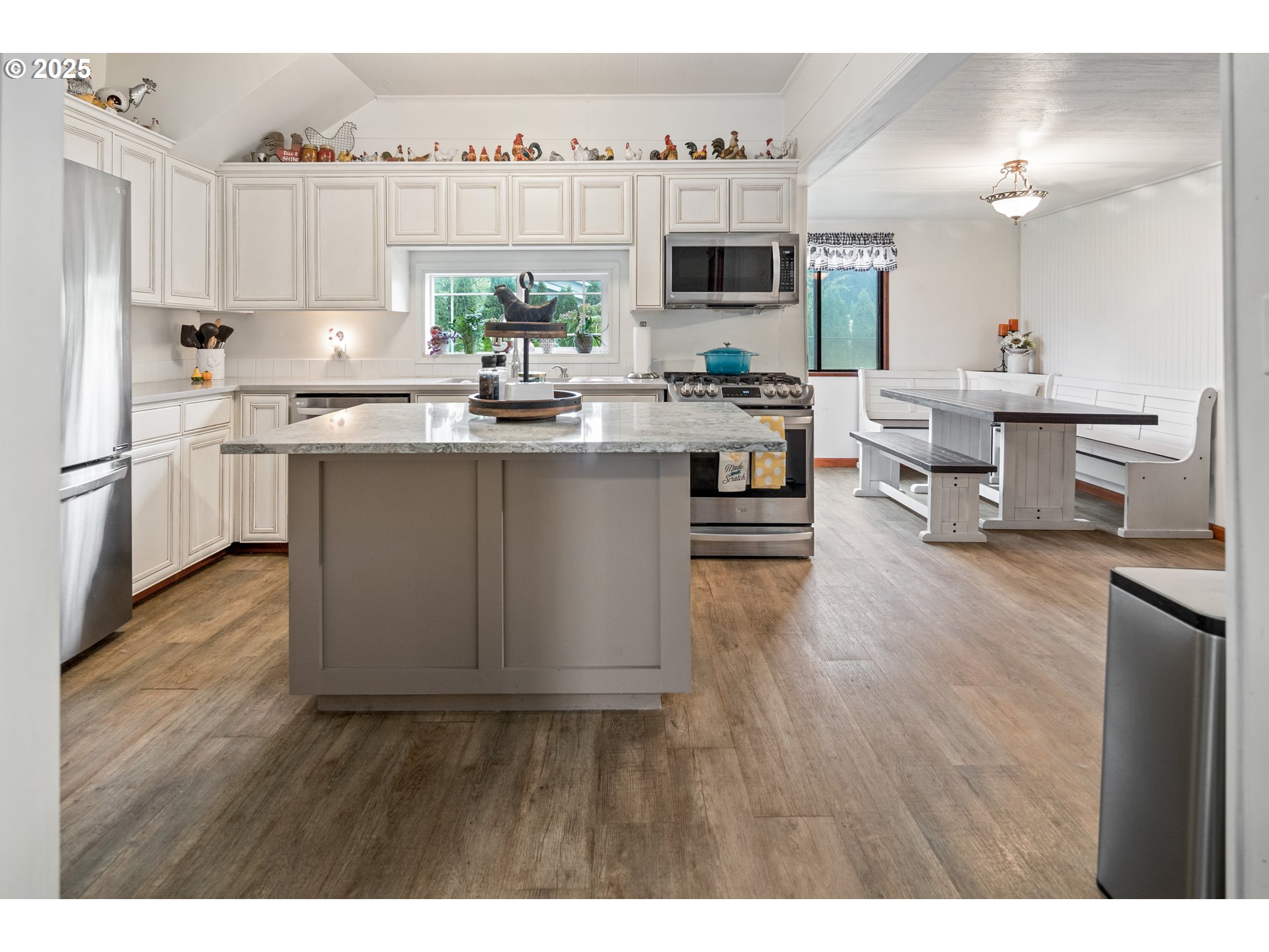 16326 Butteville Road Northeast Woodburn, OR 97071 - Photo 18 of 48 a kitchen with kitchen island granite countertop a sink cabinets and wooden floor