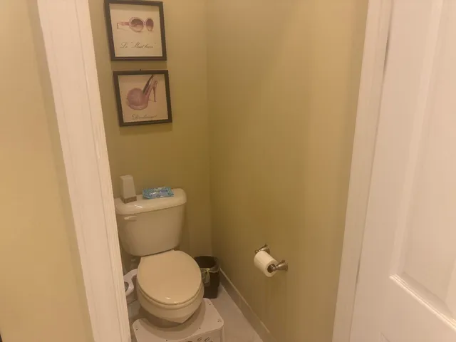 a white toilet sitting next to a white wall