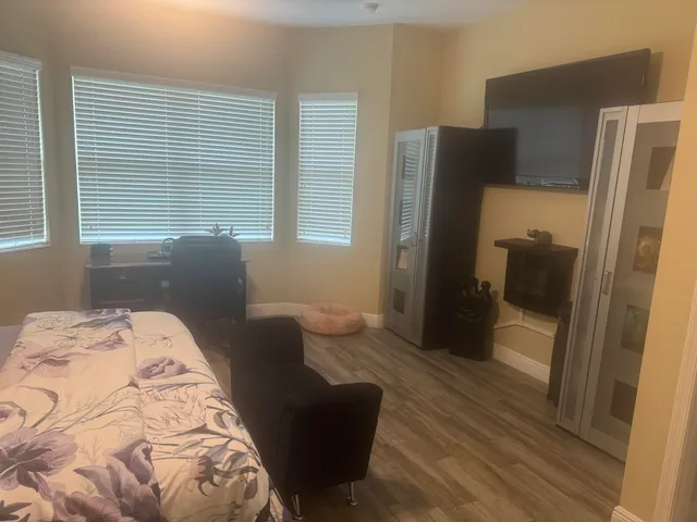a bedroom with a bed and a refrigerator
