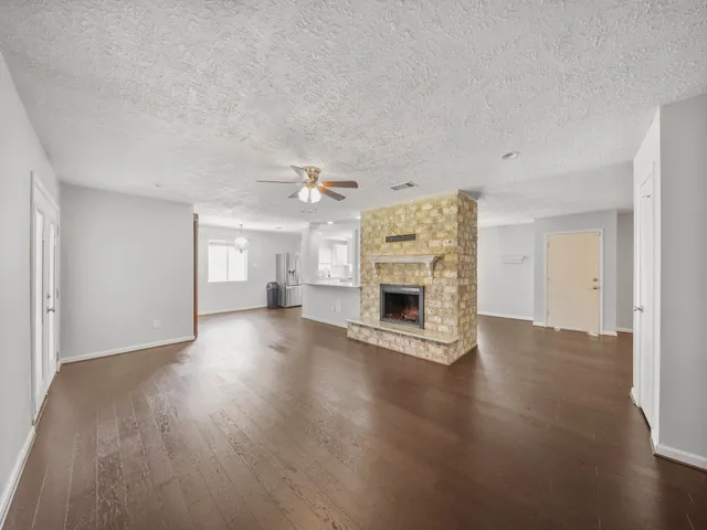 a view of empty room with wooden floor and fireplace