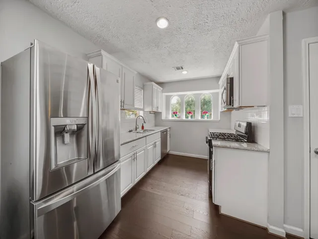 a kitchen with stainless steel appliances a refrigerator sink and stove