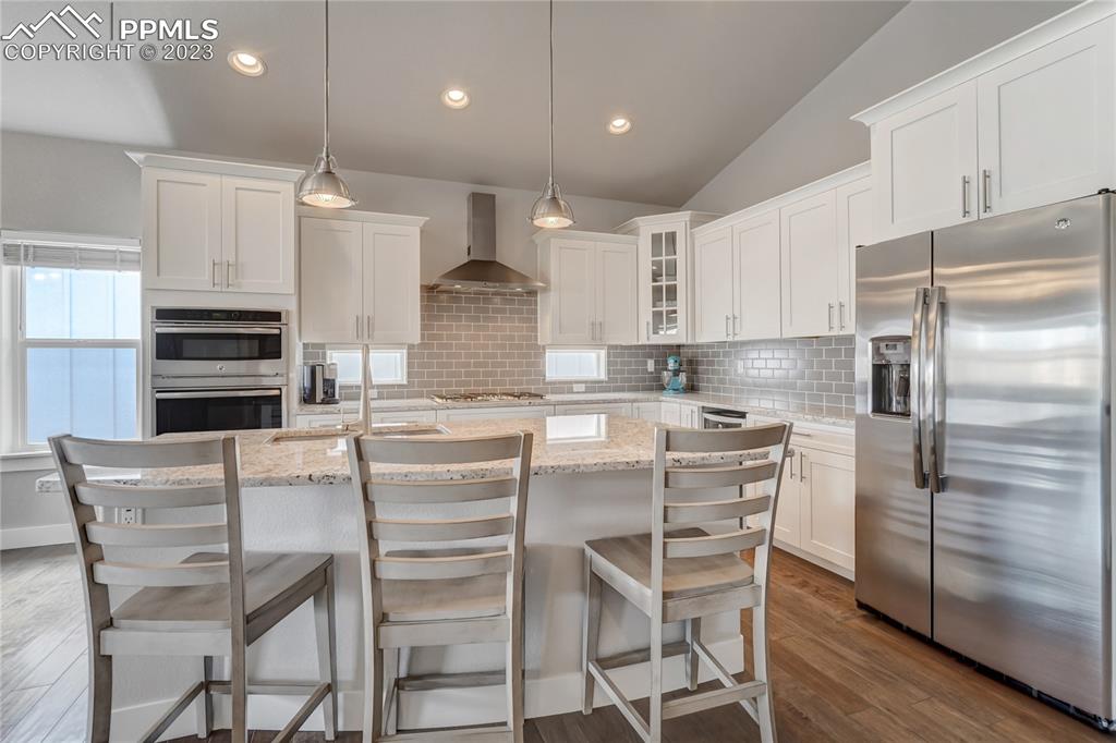 11590 Spectacular Bid Circle Colorado Springs, CO 80921 - Photo 11 of 49 a kitchen with kitchen island white cabinets and stainless steel appliances