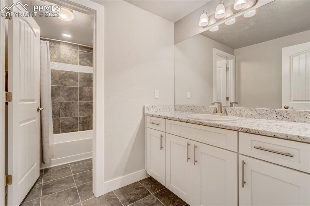 11590 Spectacular Bid Circle Colorado Springs, CO 80921 - Photo 31 of 49 a bathroom with a granite countertop sink a toilet and shower
