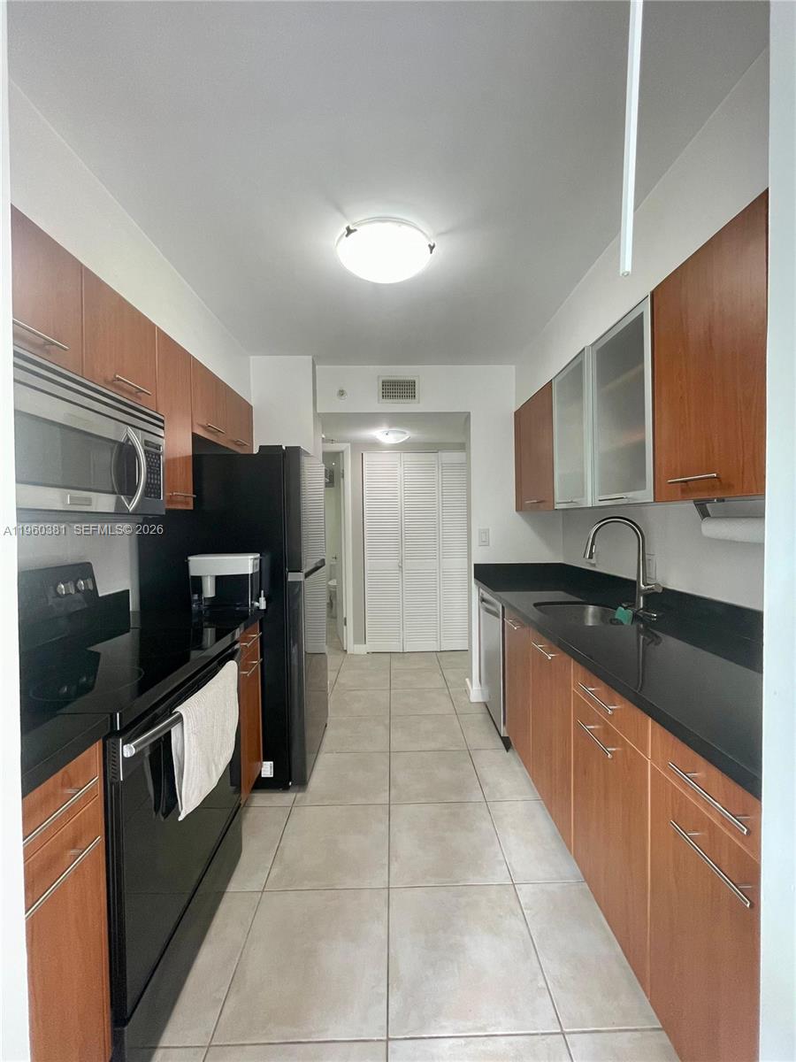 700 Northeast 63rd Street, Unit D203 Miami, FL 33138 - Photo 18 of 36 a large kitchen with a large counter top stainless steel appliances and cabinets