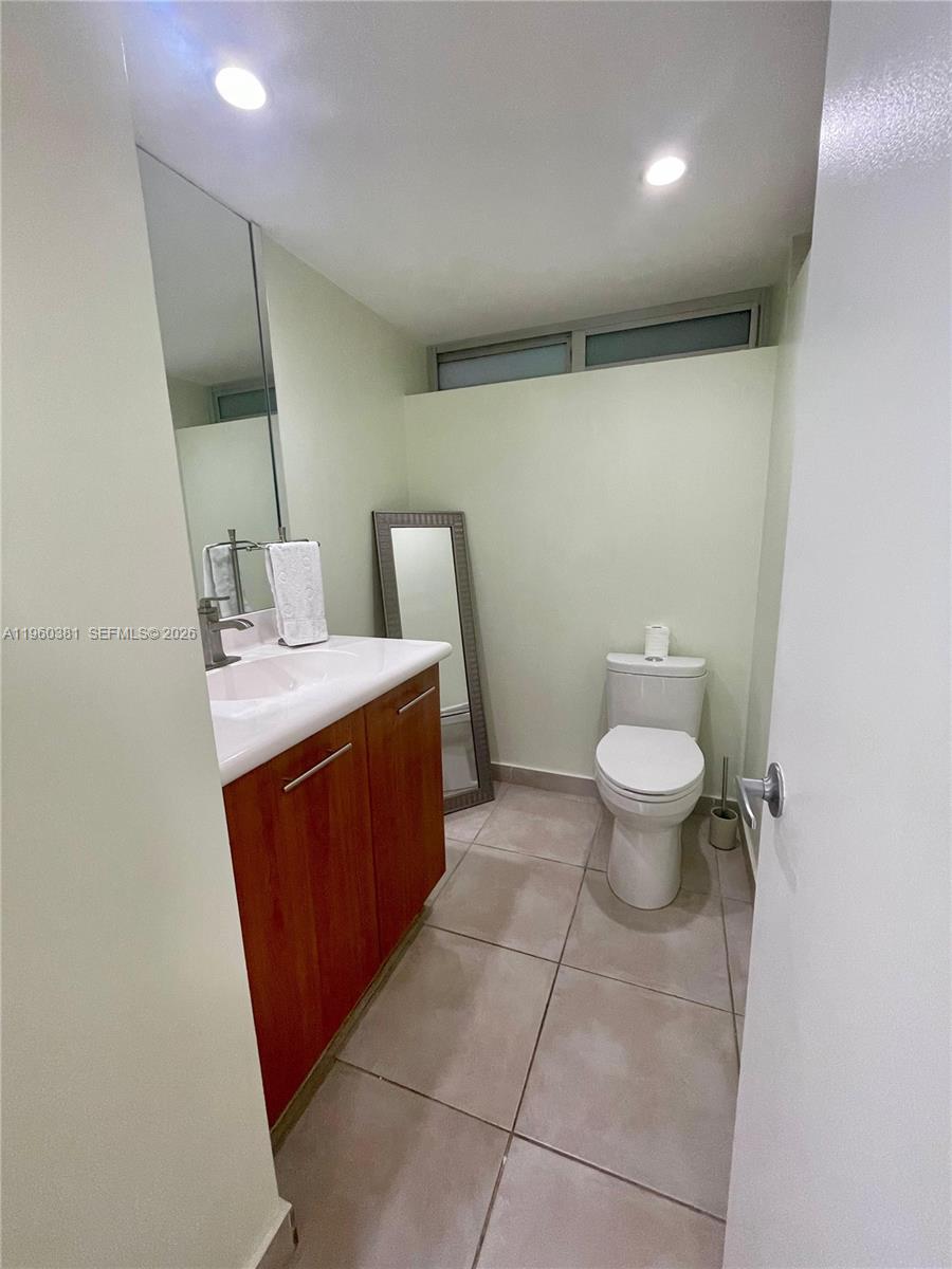 700 Northeast 63rd Street, Unit D203 Miami, FL 33138 - Photo 19 of 36 a bathroom with a sink a toilet and mirror