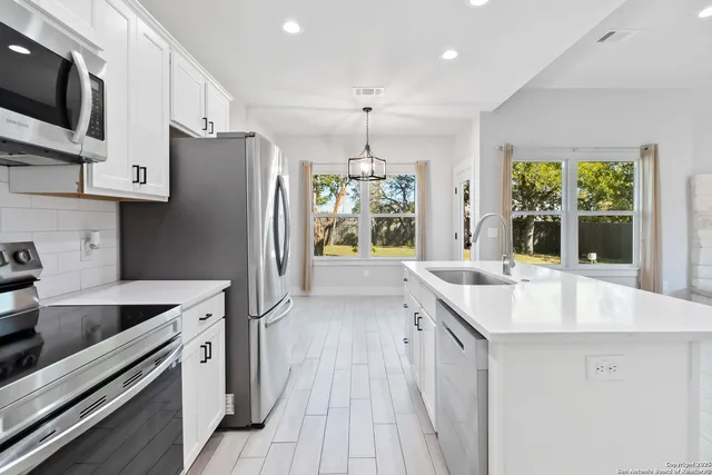 a kitchen with a sink stove and refrigerator