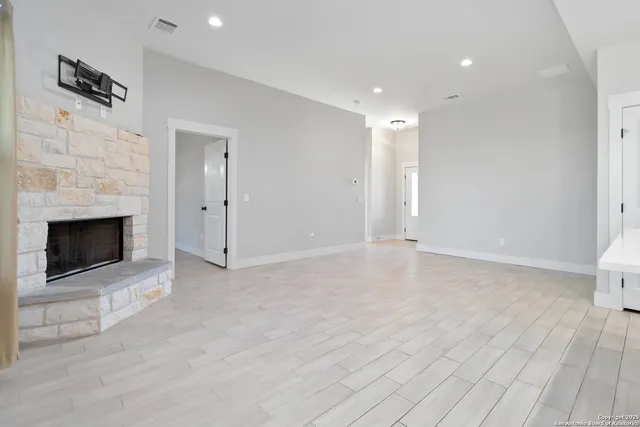 a view of empty room with wooden floor and fireplace