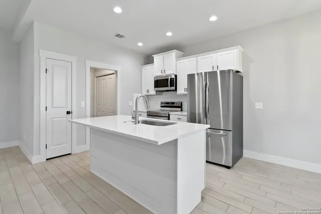 a kitchen with stainless steel appliances a refrigerator stove and microwave