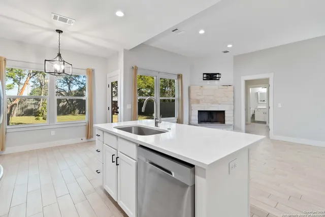a view of living room with granite countertop furniture a fireplace and a chandelier