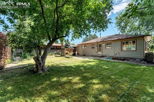 a view of a house with backyard and sitting area