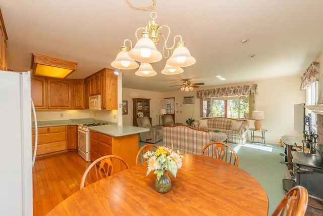 a view of a dining room with furniture a kitchen and chandelier