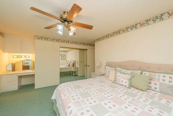 a bedroom with a large bed and a chandelier