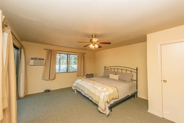 a bedroom with a bed chandelier and a window