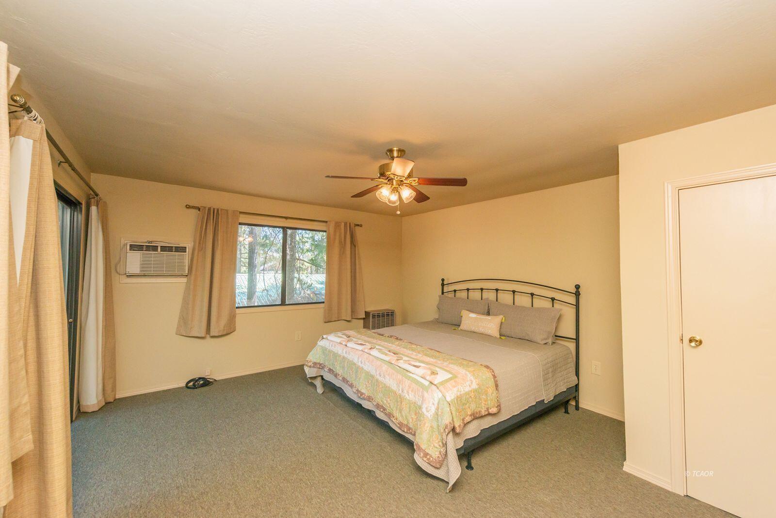 220-230 Lakeview Drive Trinity Center, CA 96091 - Photo 36 of 48 a bedroom with a bed chandelier and a window