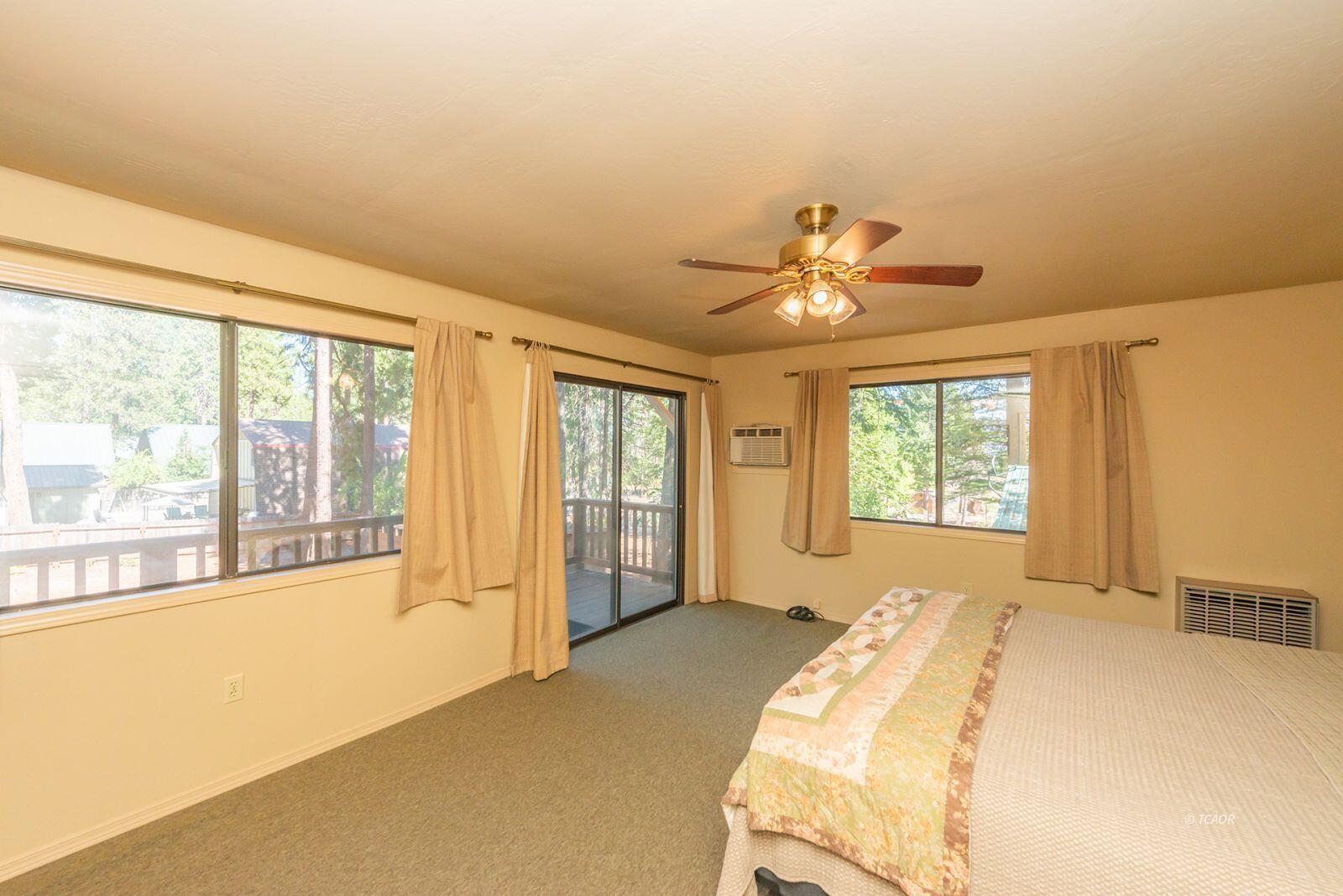 220-230 Lakeview Drive Trinity Center, CA 96091 - Photo 37 of 48 a spacious bedroom with a large bed and a large window with the outer view