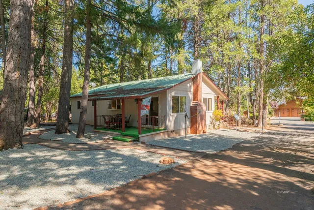 a view of a house with a tree in front of it