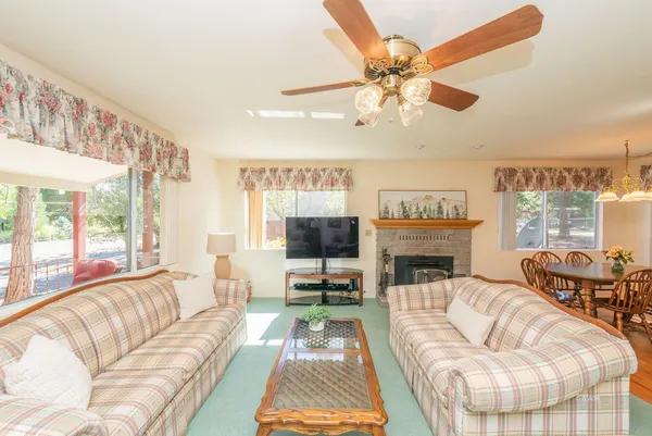 a living room with furniture a fireplace and a large window