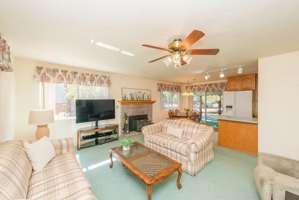 a living room with furniture a flat screen tv and a fireplace