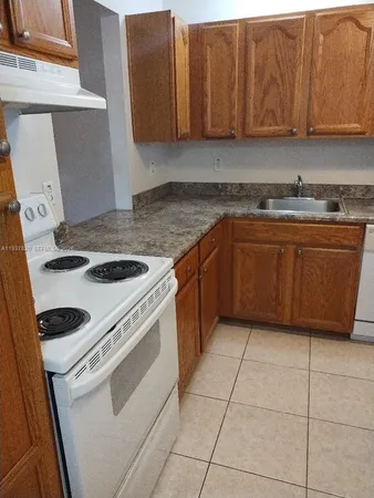 a kitchen with granite countertop cabinets and white appliances