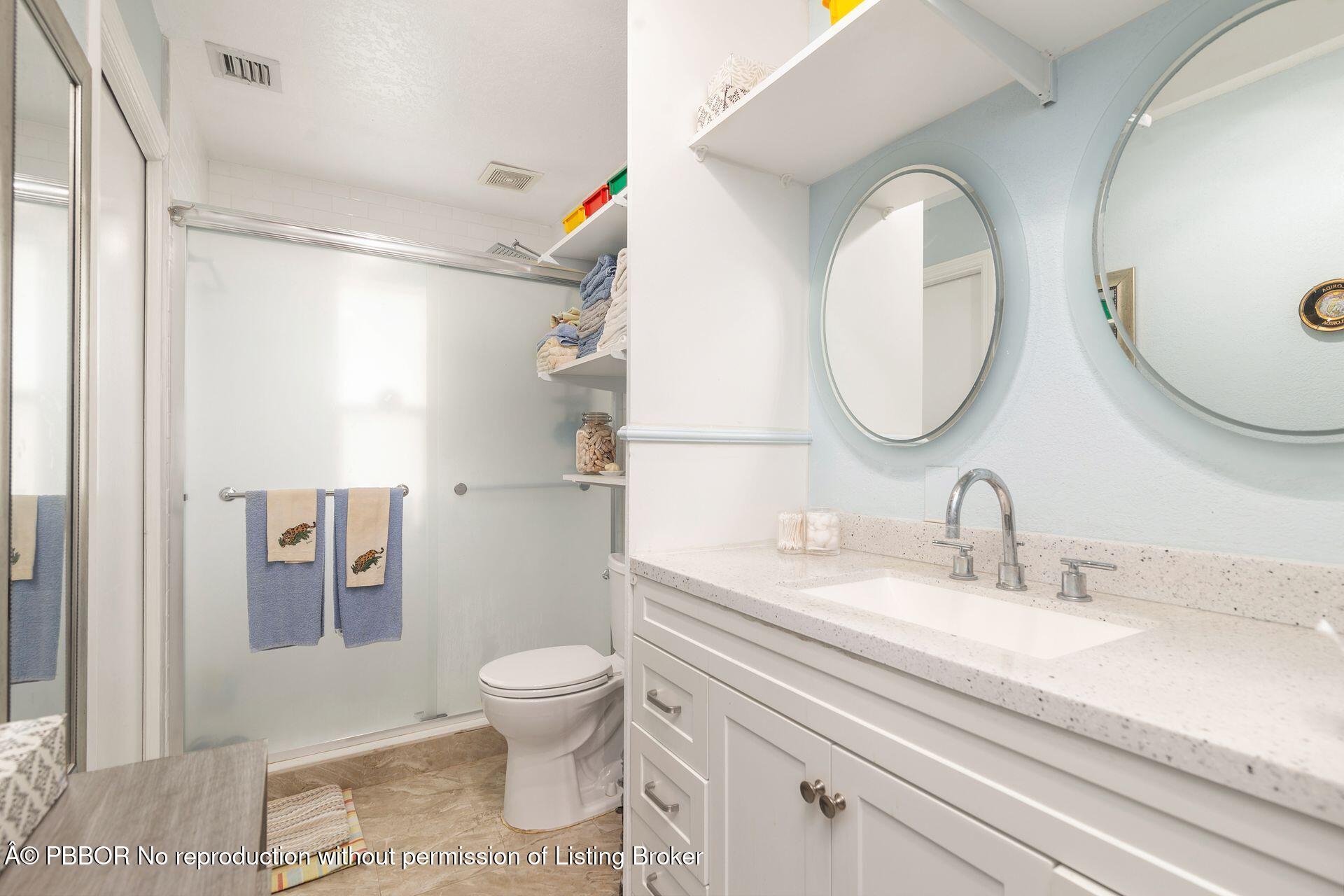 2770 E Road Loxahatchee, FL 33470 - Photo 33 of 51 a bathroom with a sink a toilet and a mirror