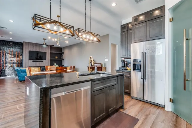 a kitchen with stainless steel appliances granite countertop a sink a refrigerator and a stove