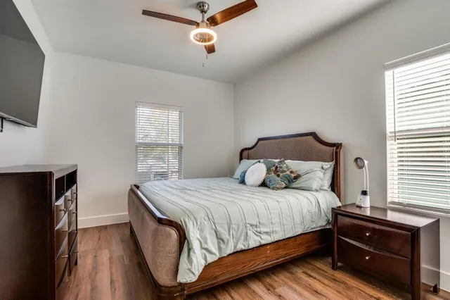 a bedroom with a bed and a flat tv screen on dresser